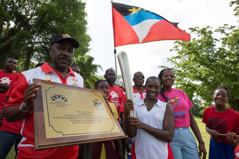 The Queen's Baton, carried by Zita Edwards (netball), relays through the Botanic Gardens stopping at the plaque that marks the dedication of Victoria Park Botanical Gardens to the Queen's Commonwealth Canopy, in Antigua, on 18 June 2017.
