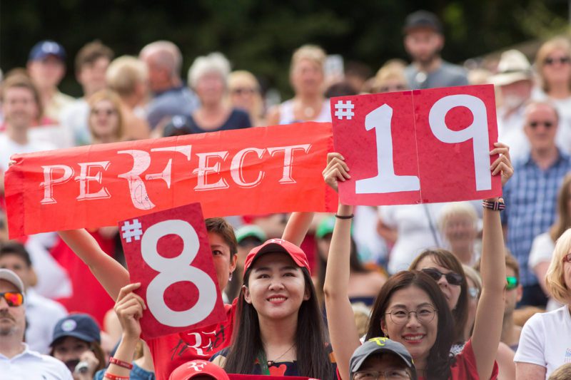 Joyous fans of Federer hoisting high the PERFECT #19 placard which symbolizes Roger Federer's Grand Slam record titles