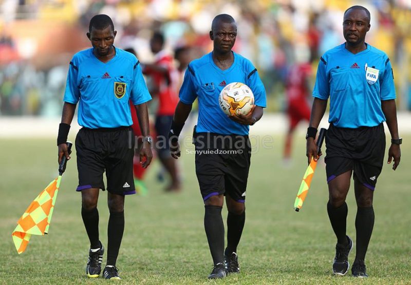 Referee Awal Mohammed [middle] and his two assistants match official walking side-by-side