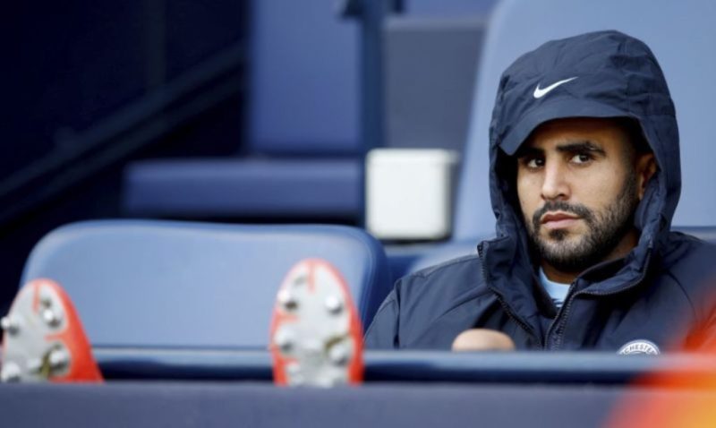 Manchester City's Riyad Mahrez sits on the substitute's bench