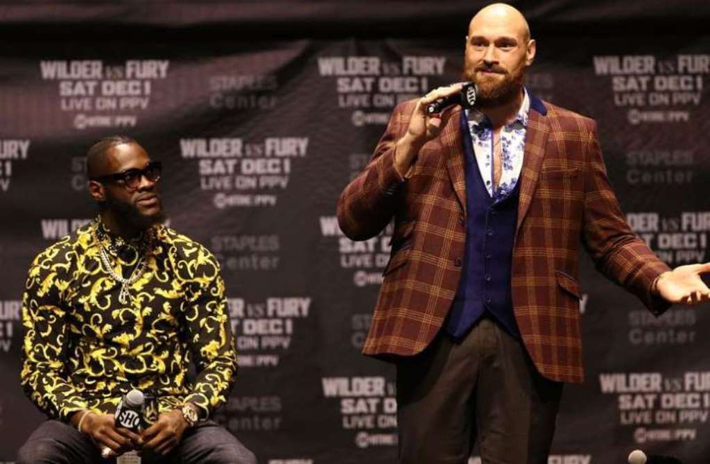 Tyson Fury [right] speaking to the media as Deontay Wilder watches on